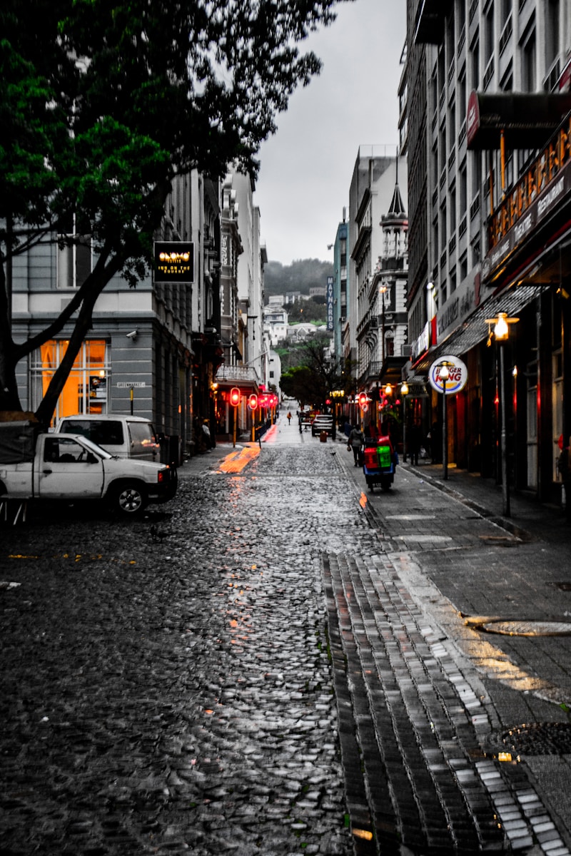 two white vehicles beside concrete buildings