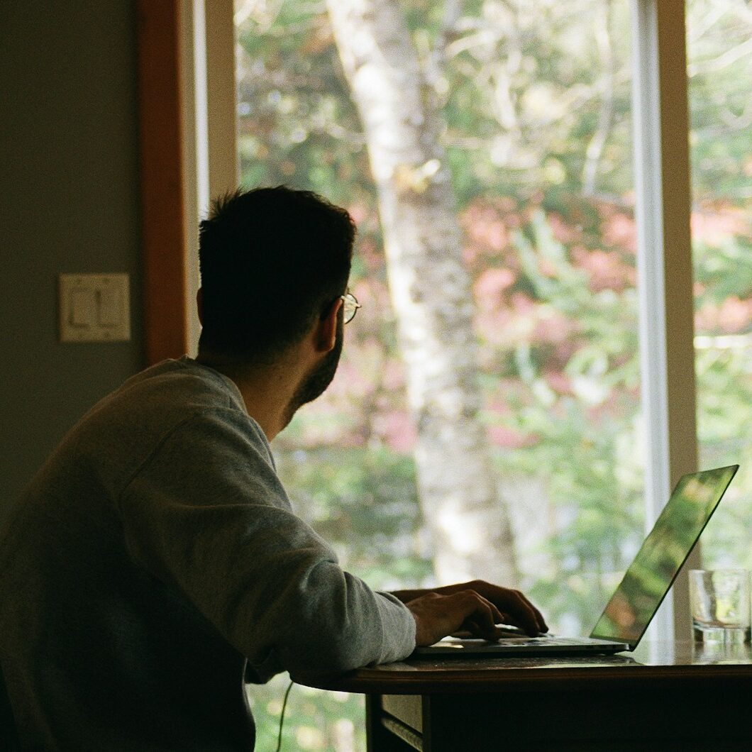 man in gray hoodie using laptop computer